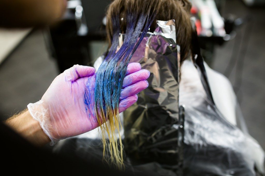 Woman's hair being dyed with blue