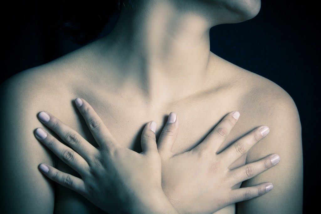 Woman covering breasts with her hands