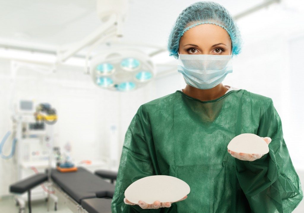 Surgeon holding silicon breast implants