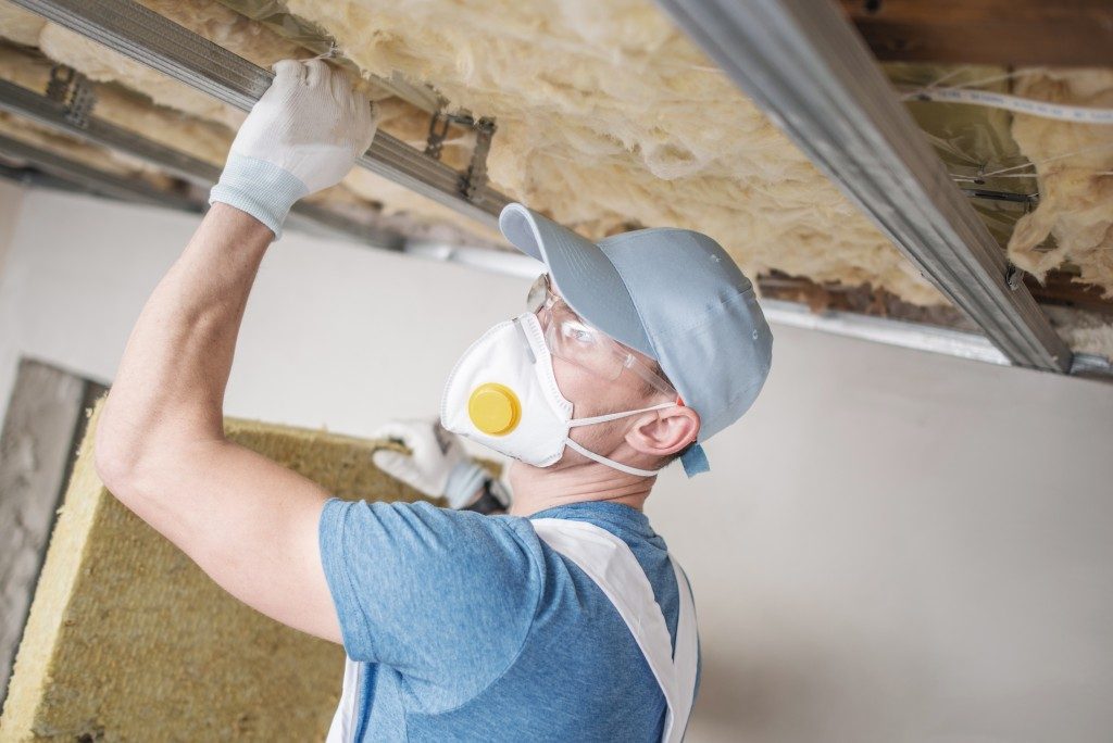 Worker insulating a house