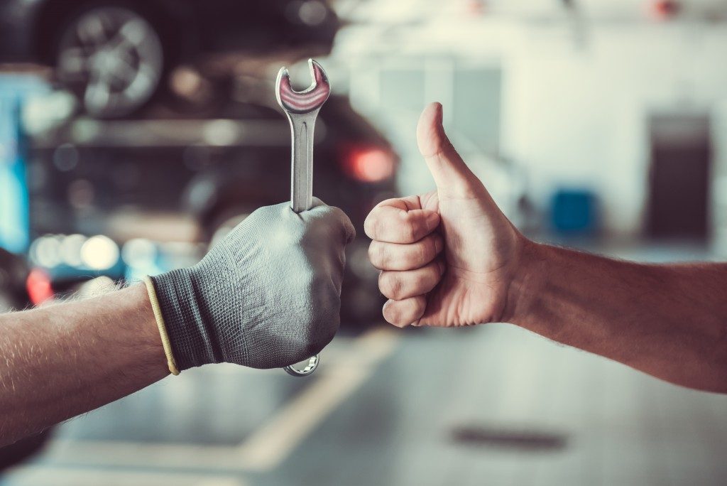 repairman with wrench and customer giving thumbsup