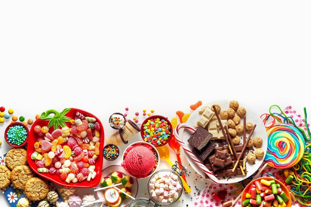 Large colorful selection of kids party food and sweets with cookies, ice cream, lollipops and candy
