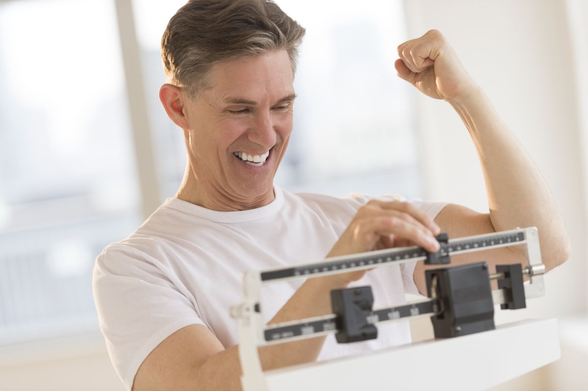 man smiling on weighing scale