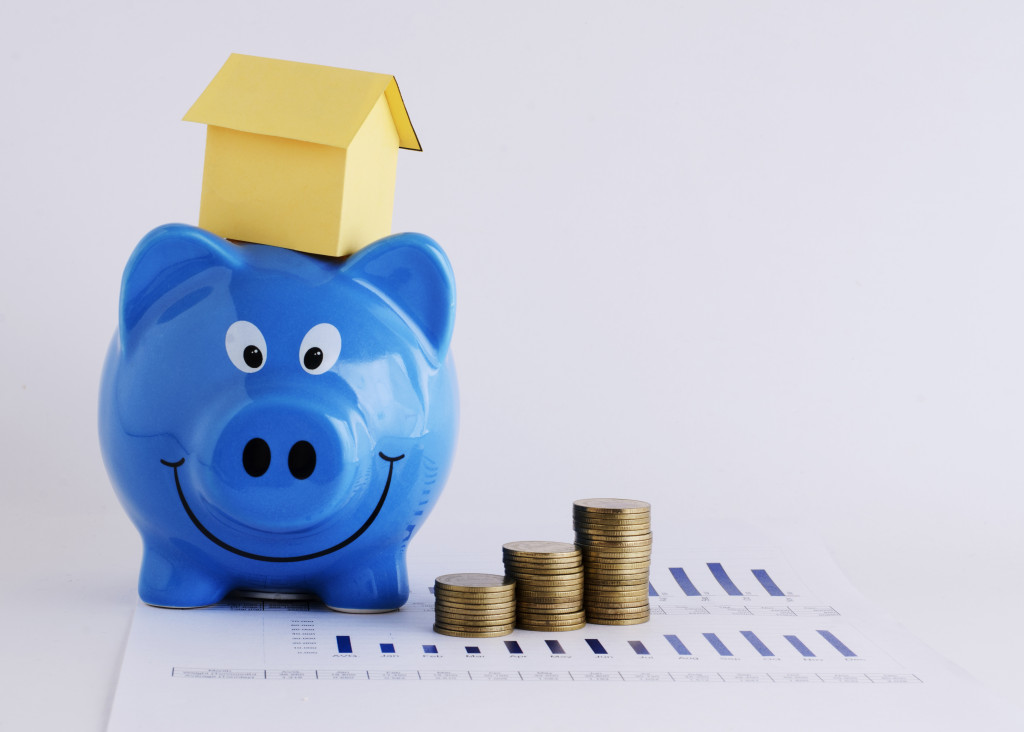 Piggy bank and paper house and coins stack