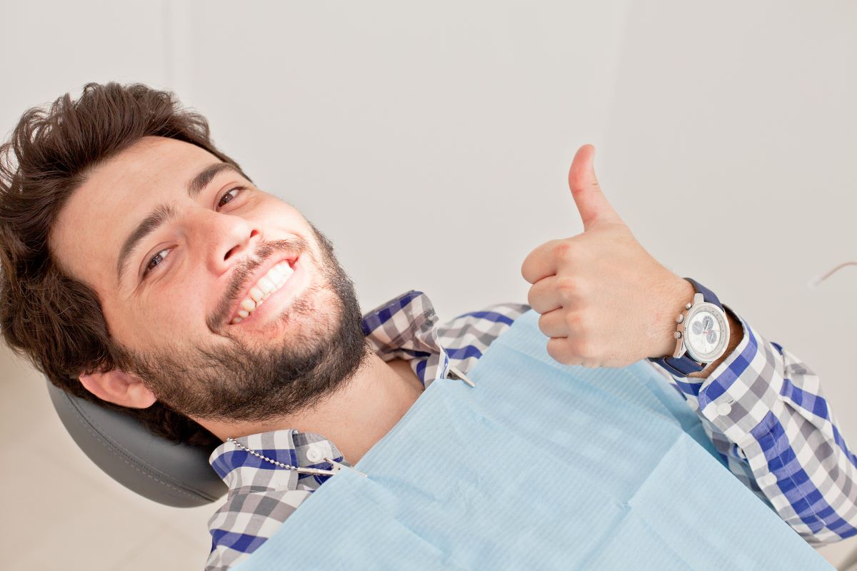 man at the dentists smiling thumbs up
