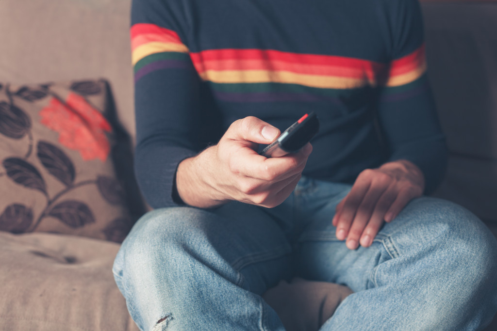 A man watching TV on a sofa