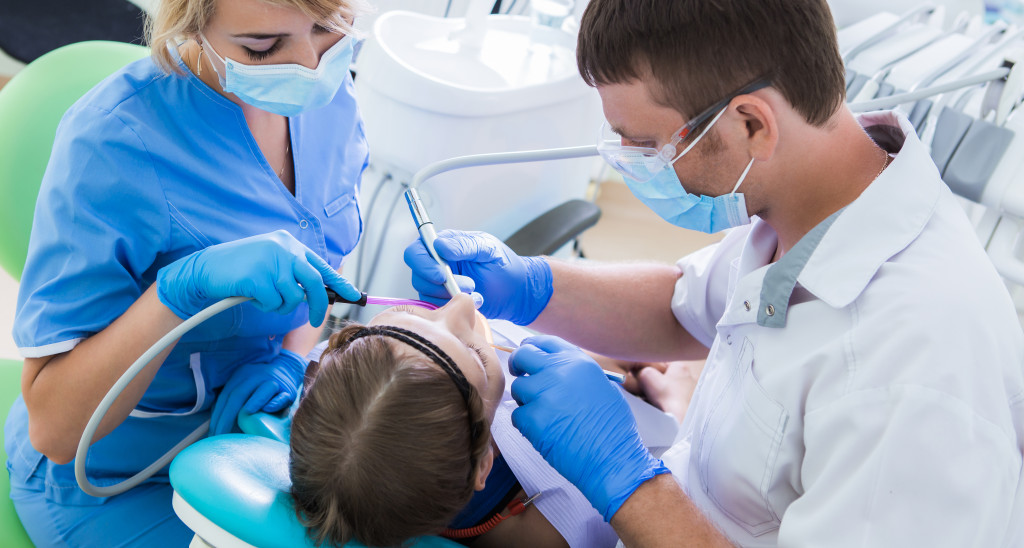 Young woman with dentist in a dental surgery.