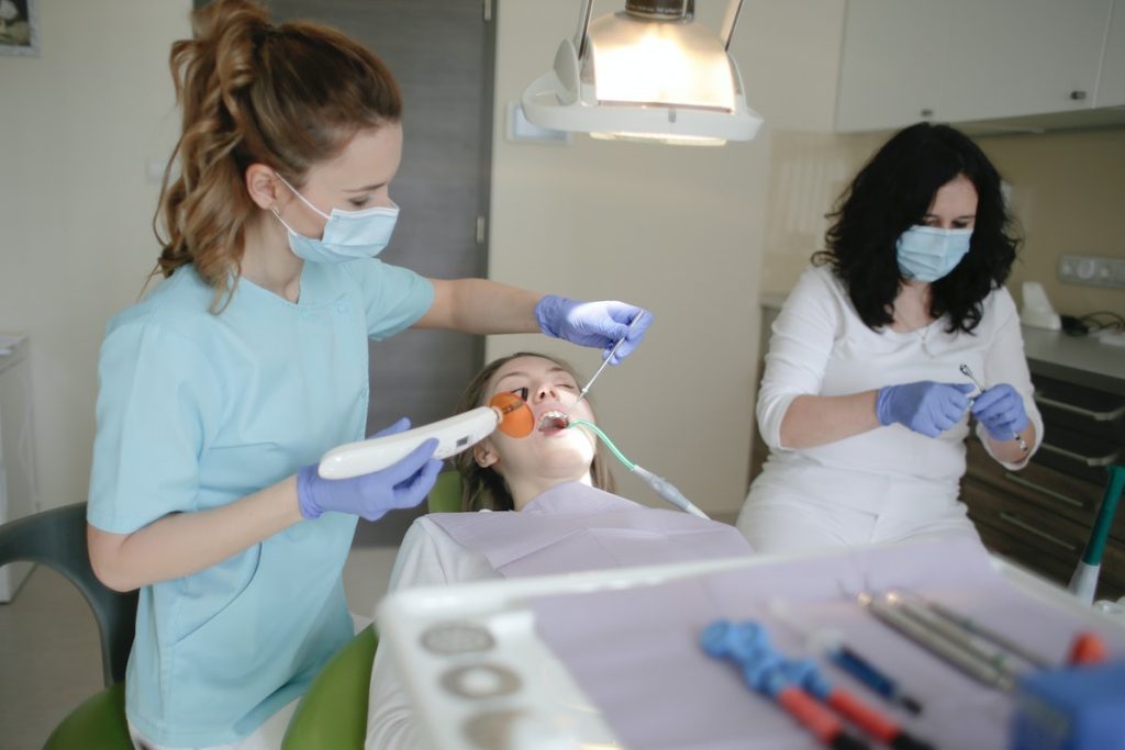 dentist doing her best to attend the needs of patient