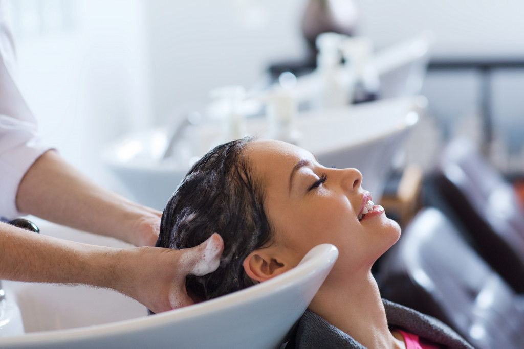 A person with dry scalp getting shampooed