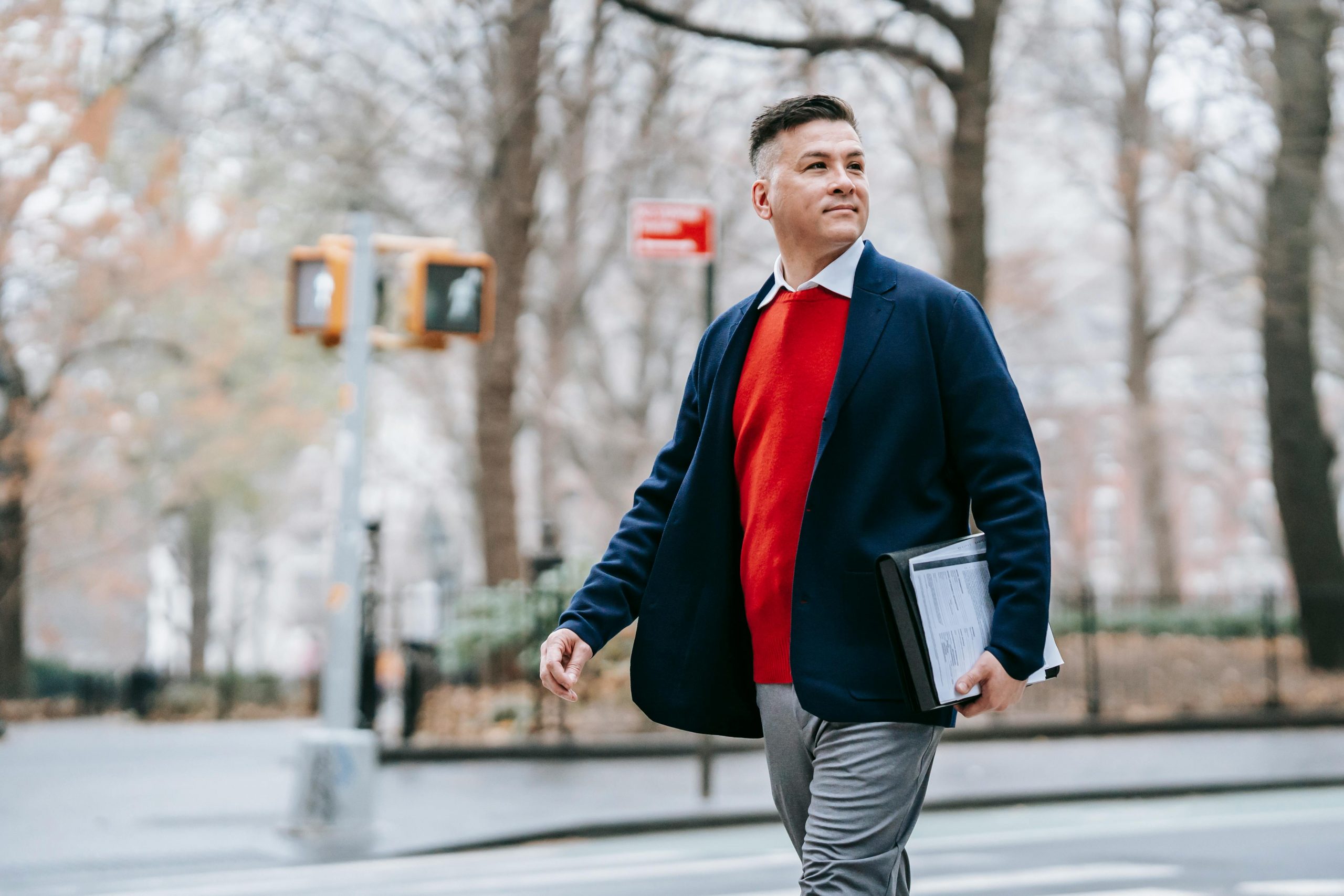 man wearing a blue blazer and orange sweater, styled for a professional look